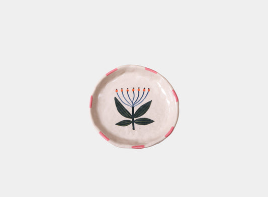 Round ceramic plate with floral design on a light gray background