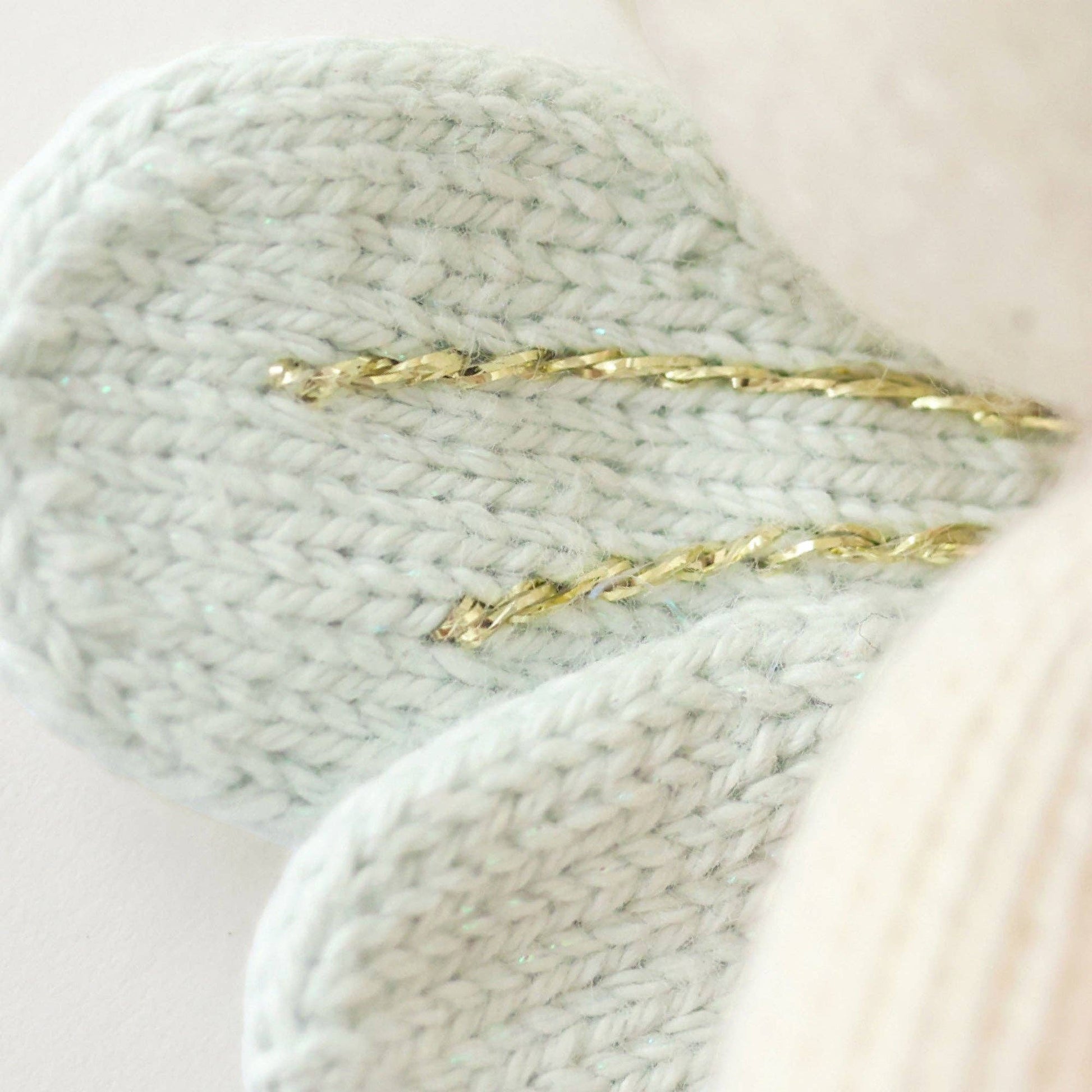Close up of knitted light blue fairy wings with gold detail