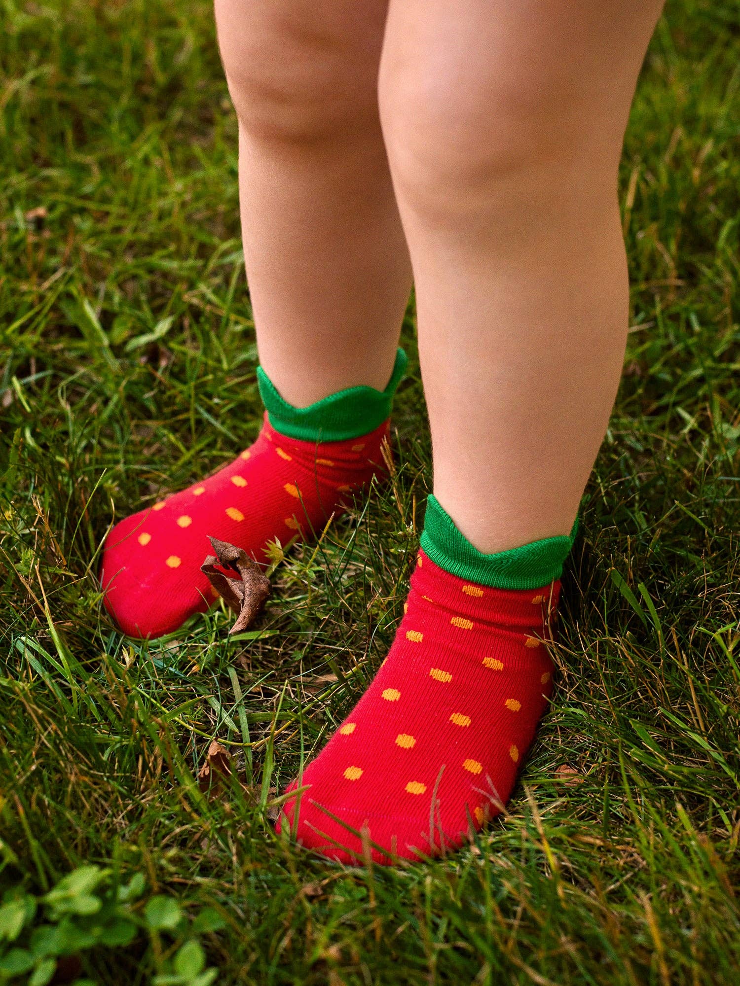 Red socks with green tops worn on grass