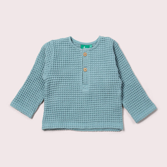 Blue textured long-sleeve shirt on a light beige background