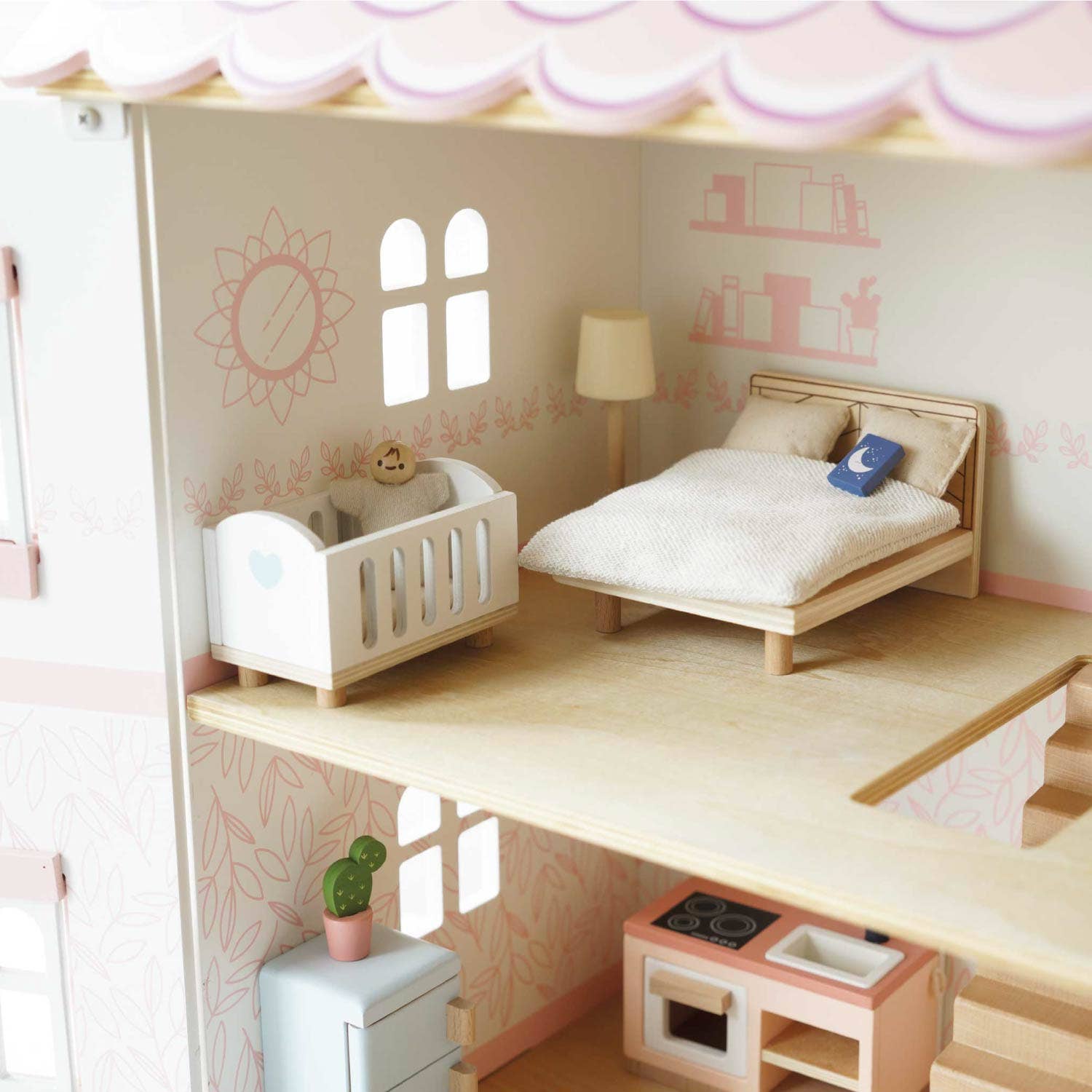 Bedroom with a bed, crib, lamp, and small kitchen area inside a dollhouse.