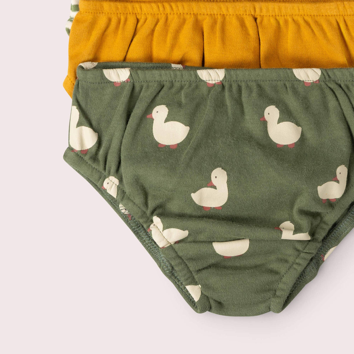 Close-up of cream duck print on olive underwear stacked with mustard and striped pairs.