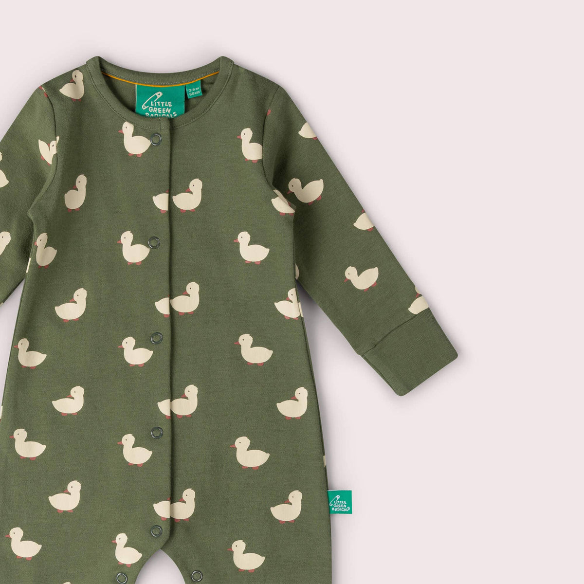 Close-up of the neckline and duck print on an olive green babygrow.