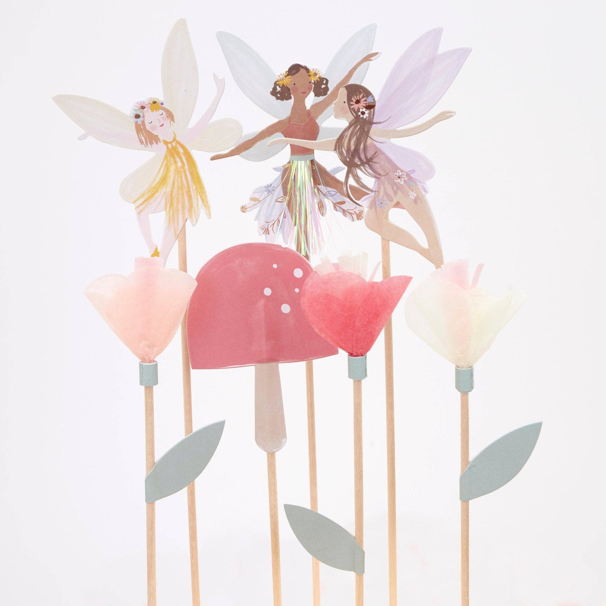 Decorative fairy figurines on sticks with colorful wings and skirts against a white background