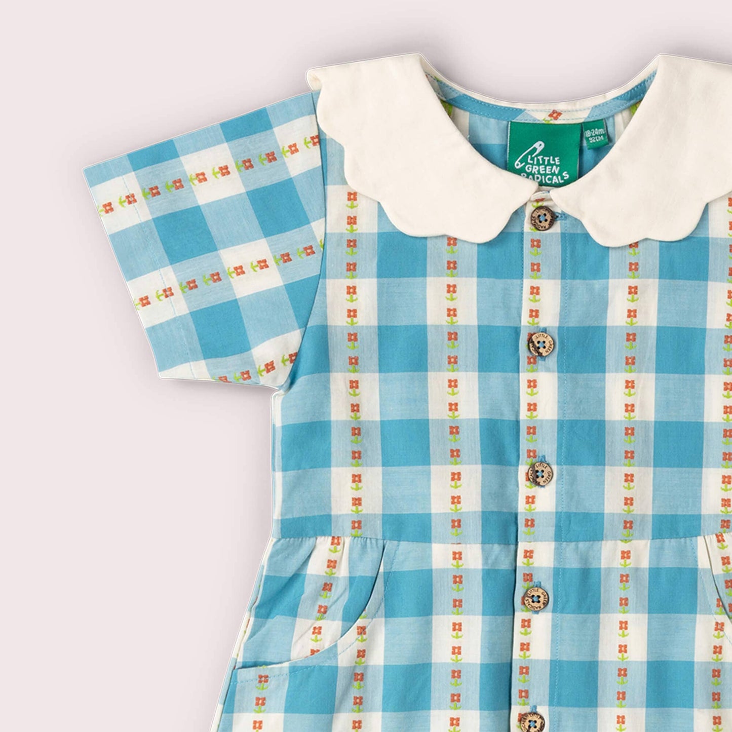 Children's blue checkered dress with white collar on a light gray background
