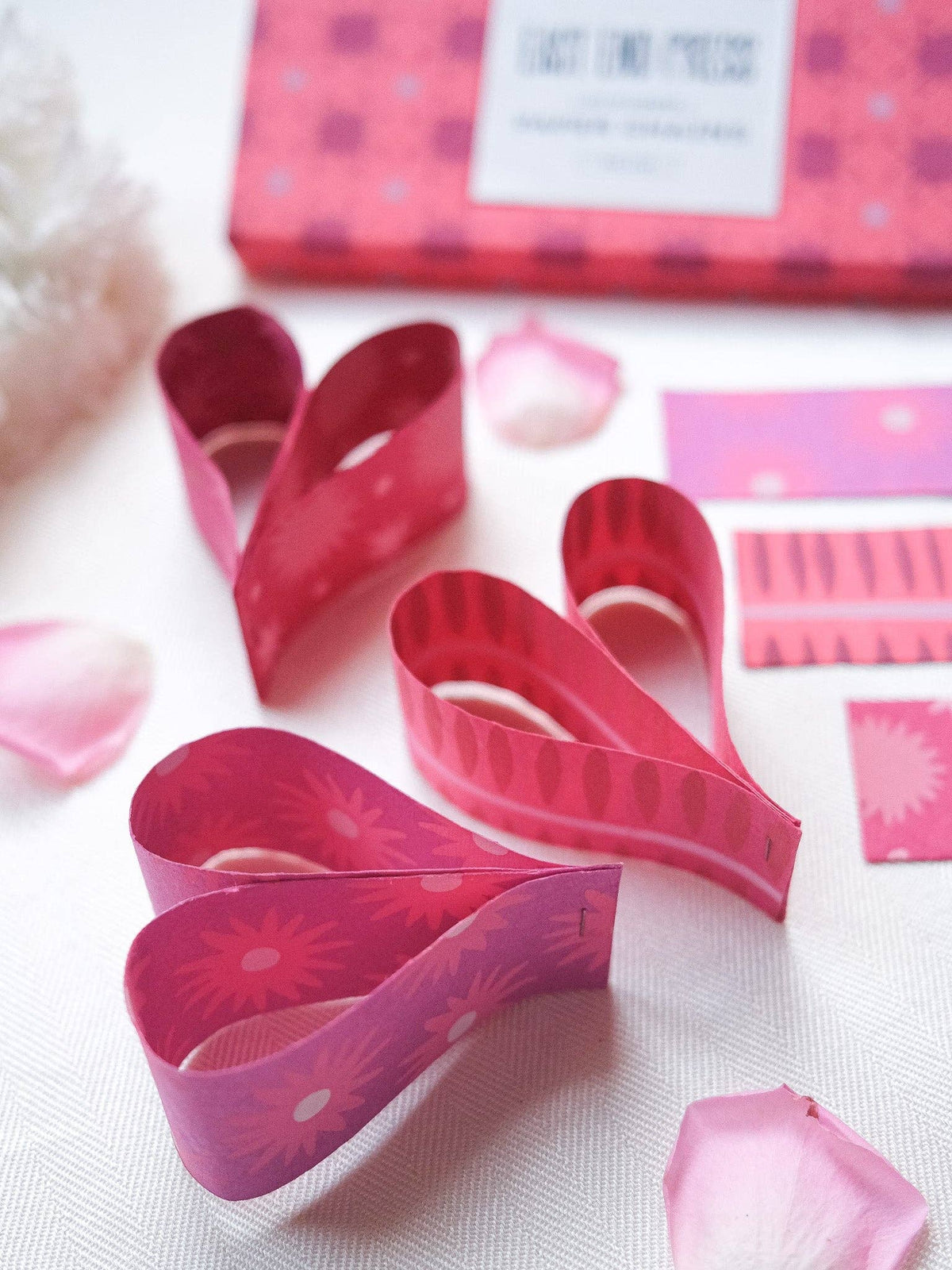 Pink and red paper chains arranged in a decorative display.