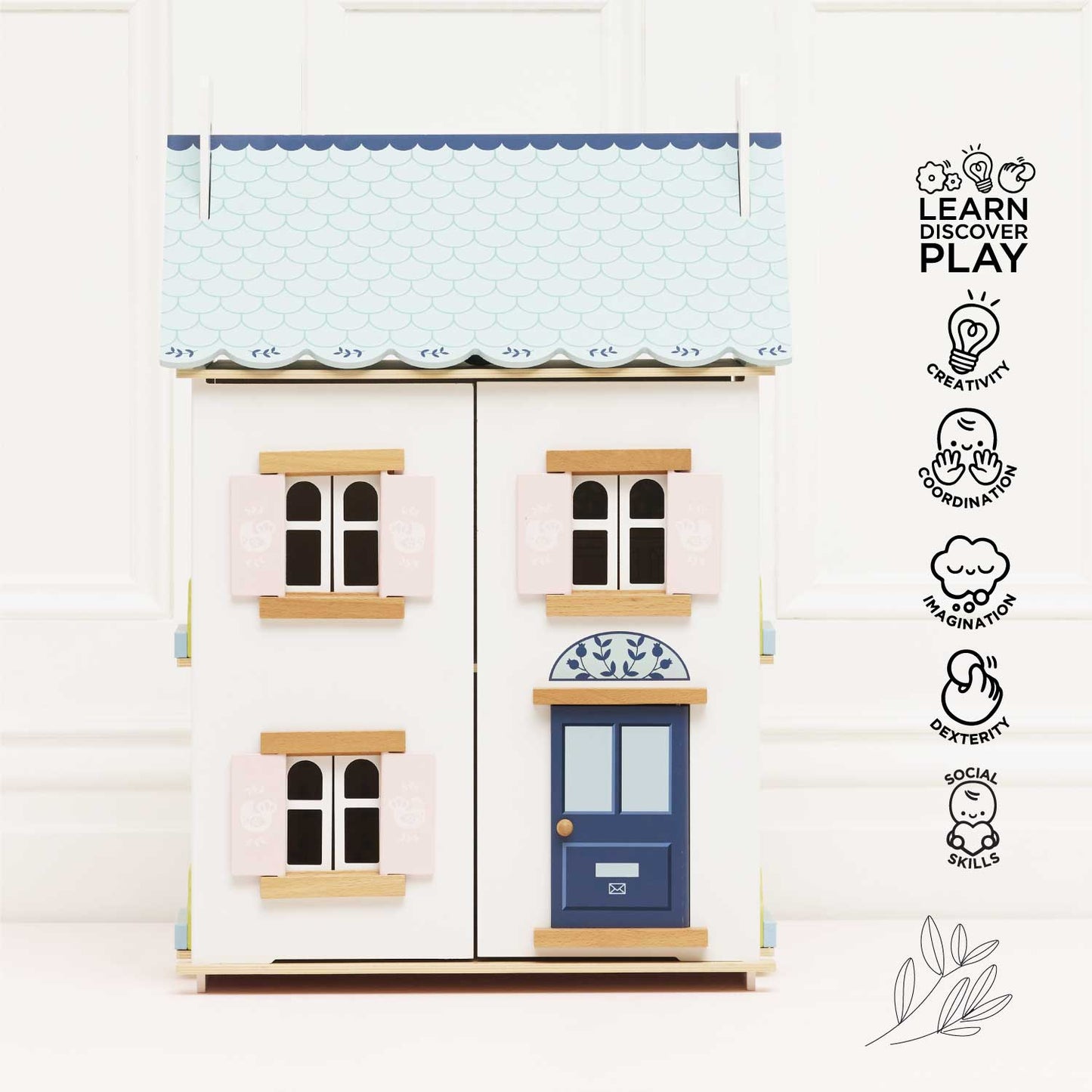 Toy house with a blue door and white walls on a light background, featuring the 'Learn Discover Play' brand.