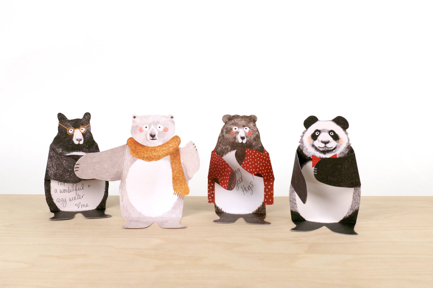 Four bear shaped cards wearing scarves on a white background