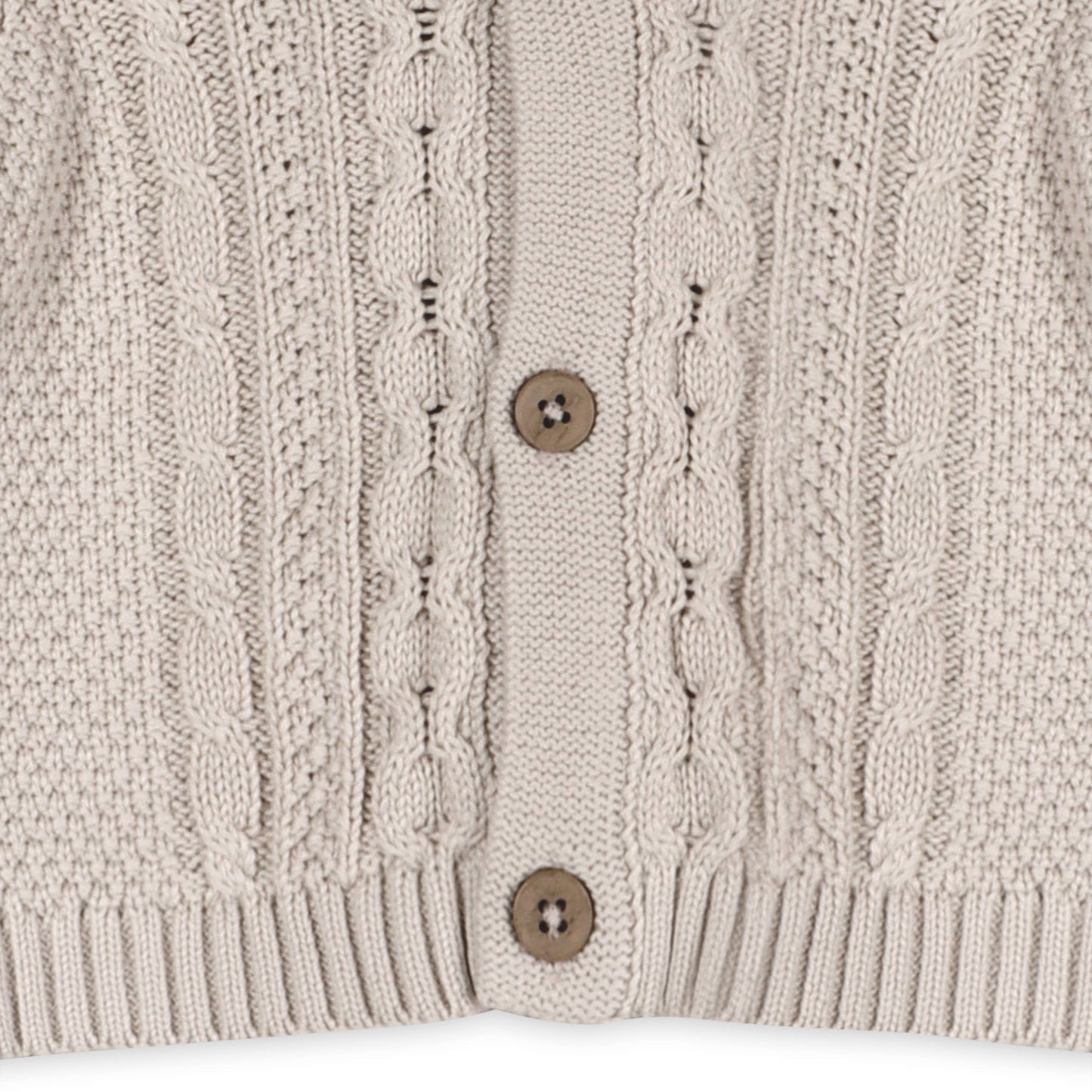 Close-up of a beige knitted cardigan with button details on a white background
