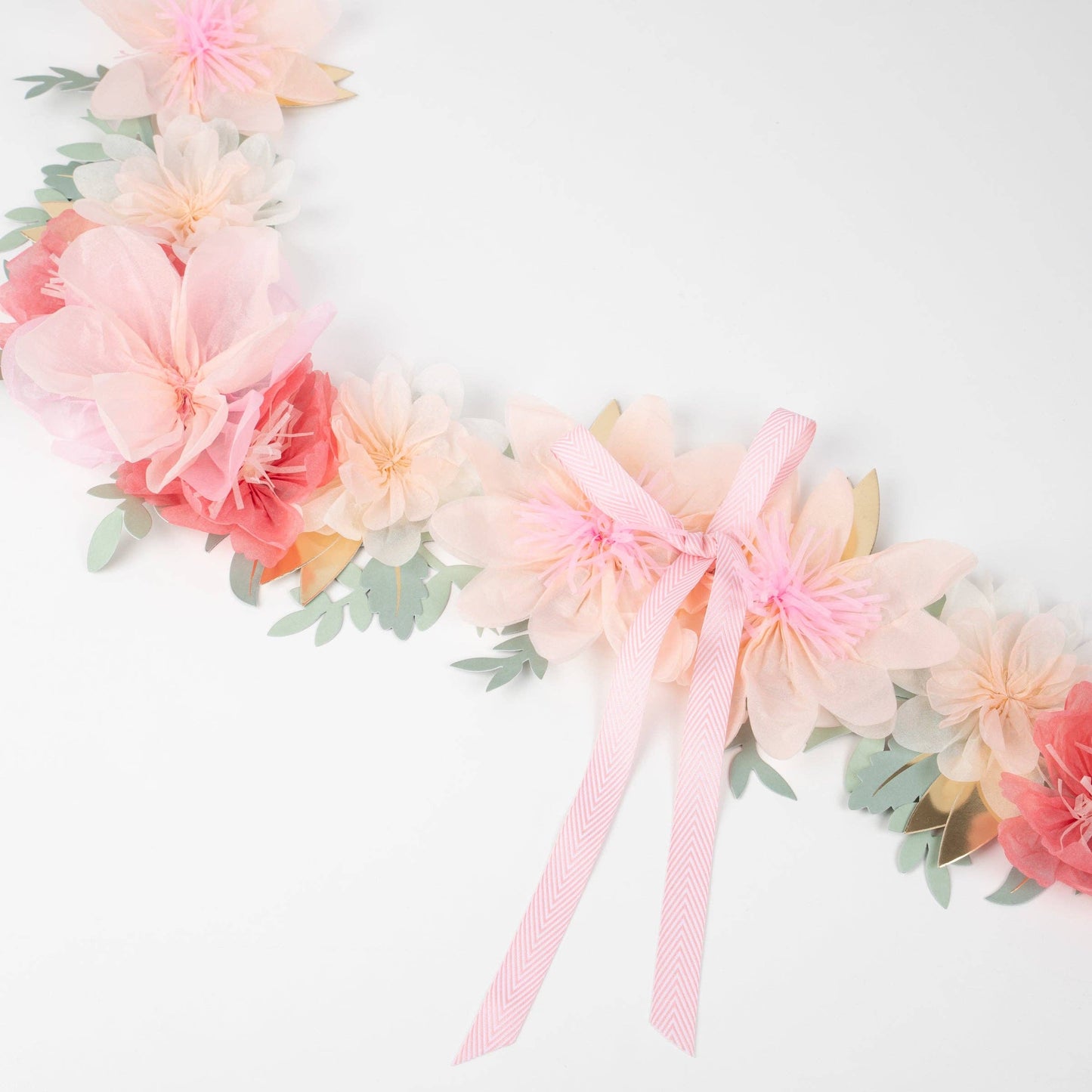Floral headband with pink and peach flowers and a pink bow on a white background