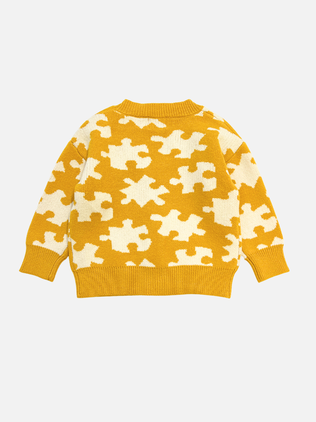 Yellow sweater with white puzzle piece pattern on a light gray background