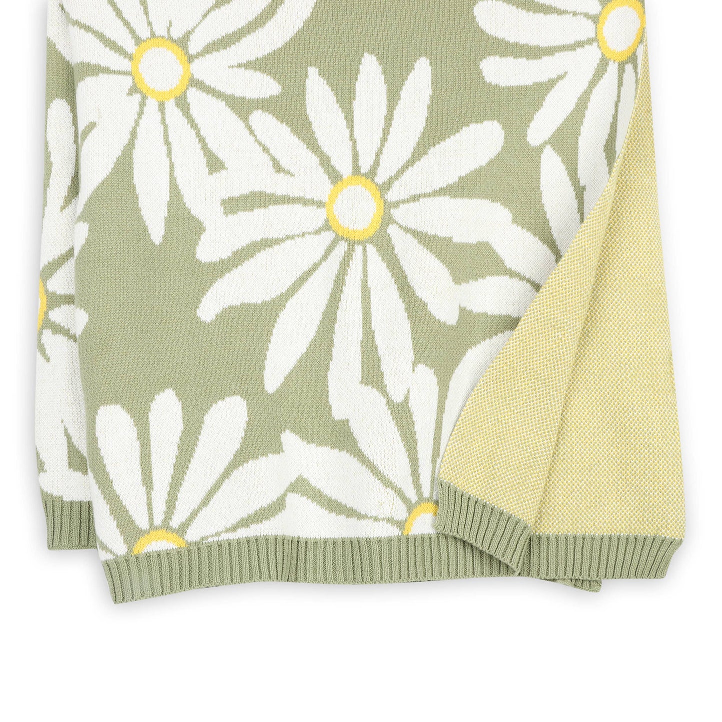 Floral patterned blanket with white flowers and yellow centers on a green background