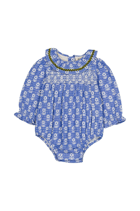 Smocked blue baby romper with ruffle collar on a white background