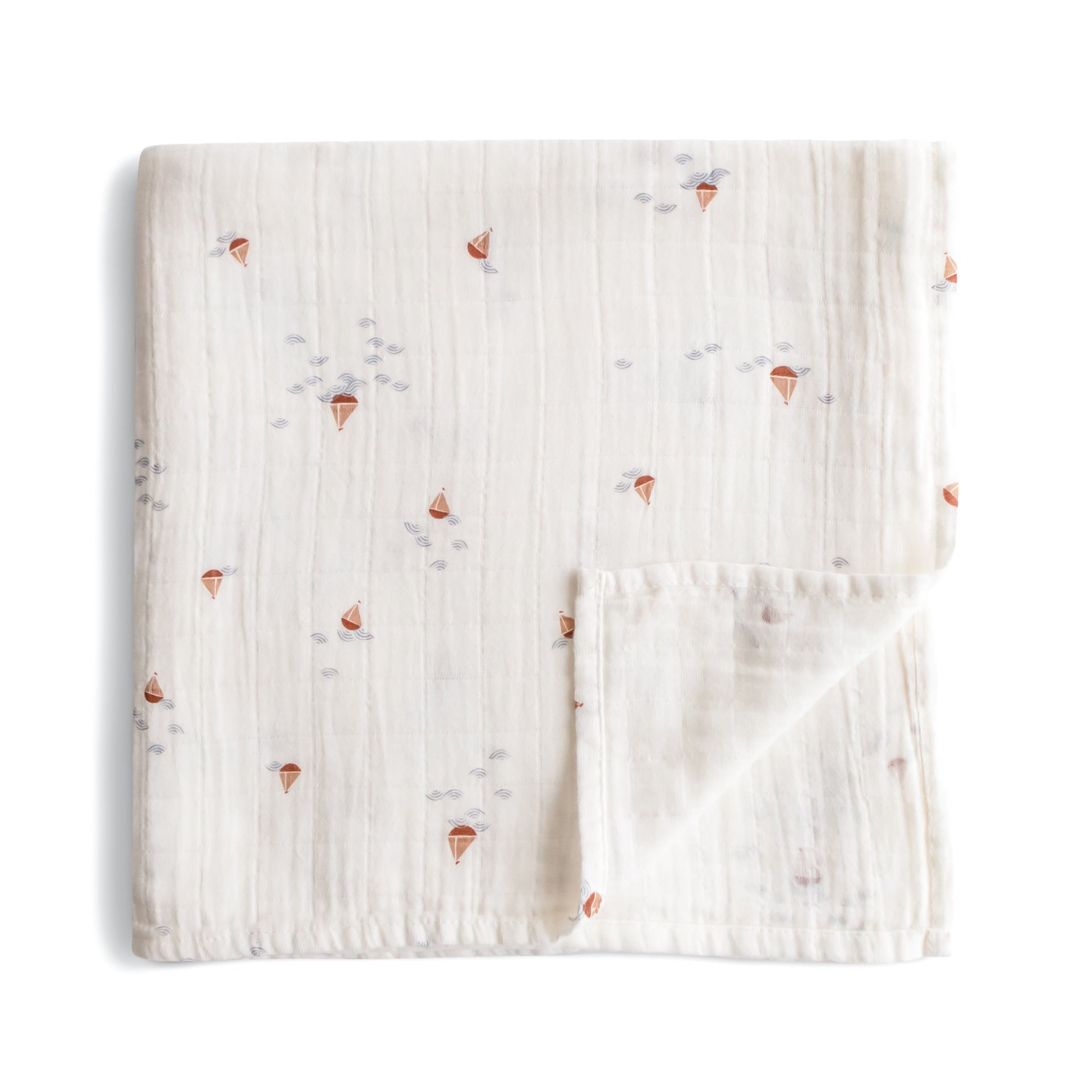 Folded fabric with small colorful sailboat designs on a white background