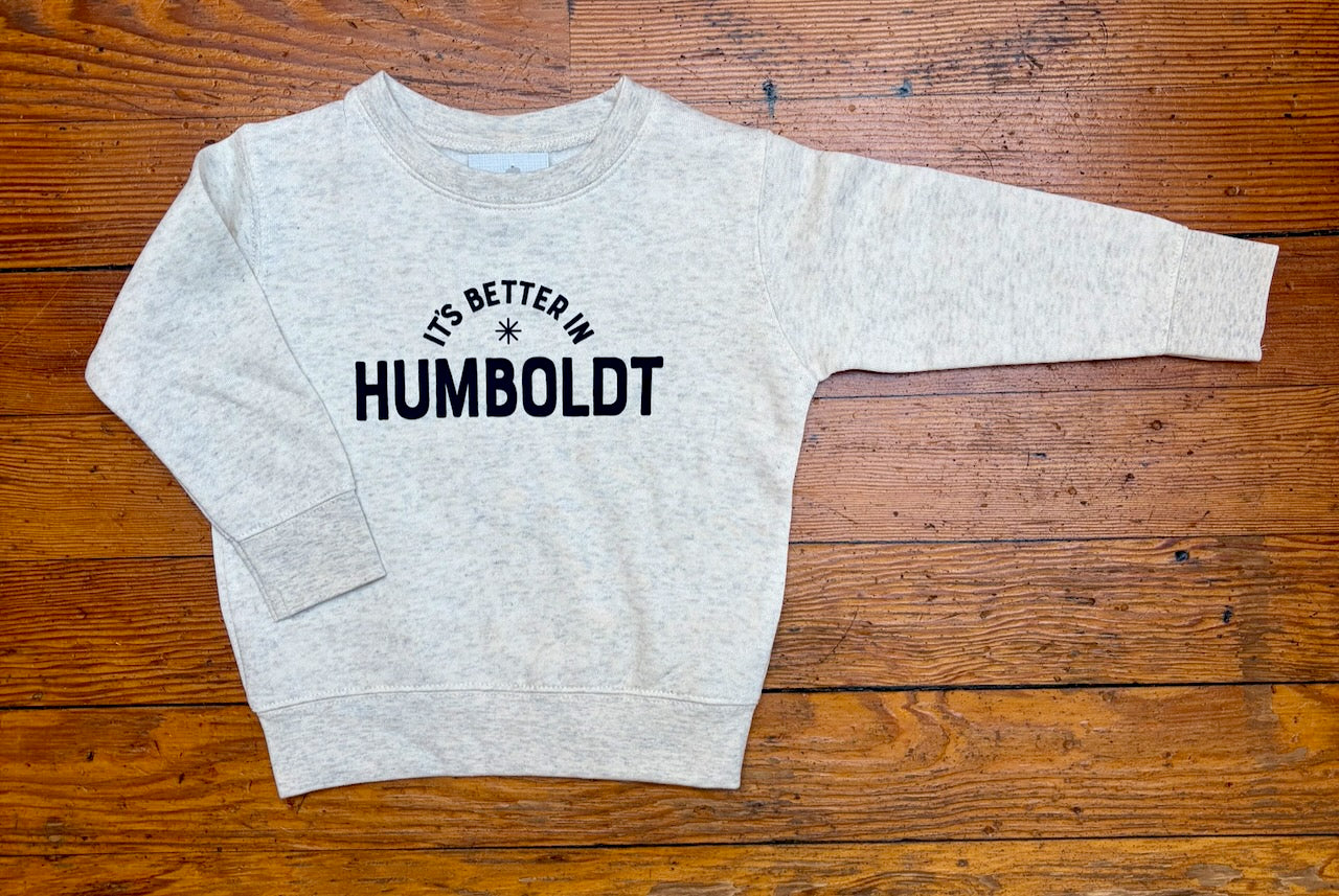 Gray sweatshirt with 'It's Better in Humboldt' text on a wooden surface