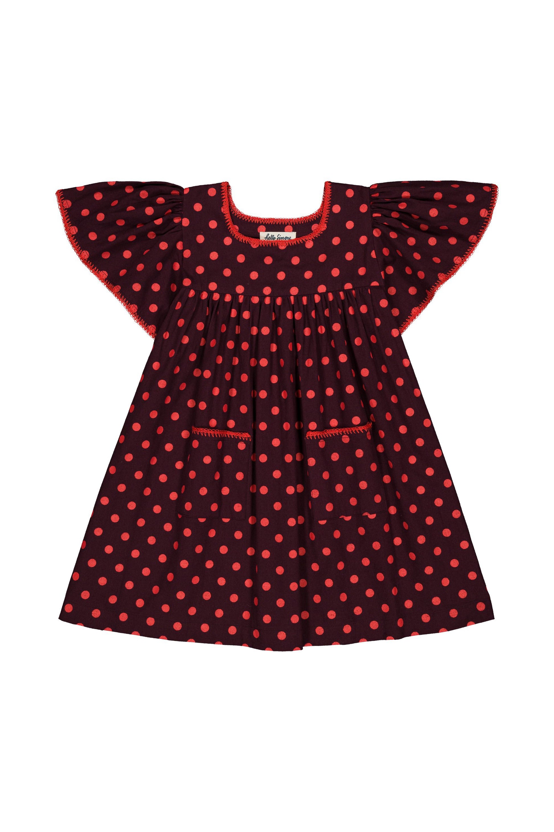 A toddler girl's dress featuring a dark red base with a red-orange polka dot pattern, ruffled cap sleeves, and a smocked neckline, shown against a plain white background.