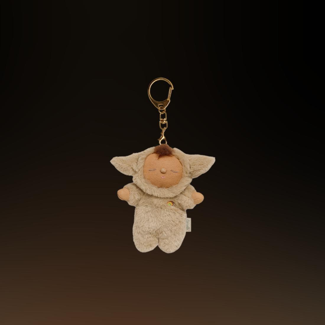 Plush keychain of a Olli Ella lamby pip character in a beige outfit with a dark background