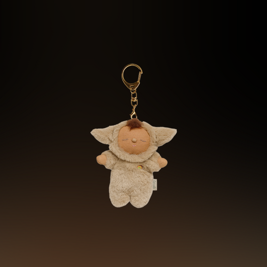Plush keychain of a Olli Ella lamby pip character in a beige outfit with a dark background