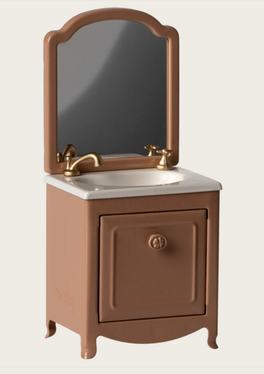 Brown dollhouse bathroom vanity with sink and mirror on a beige background
