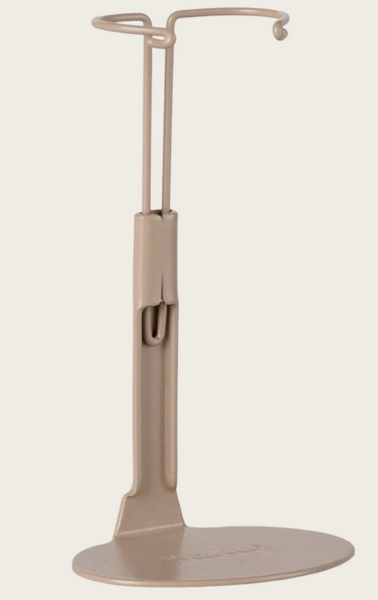 Beige doll stand with circular base and curved top on a white background