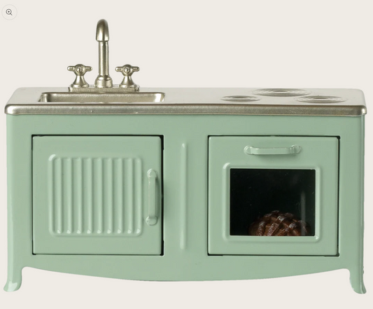 Green vintage-style kitchen stove dollhouse toy with sink and oven on a white background
