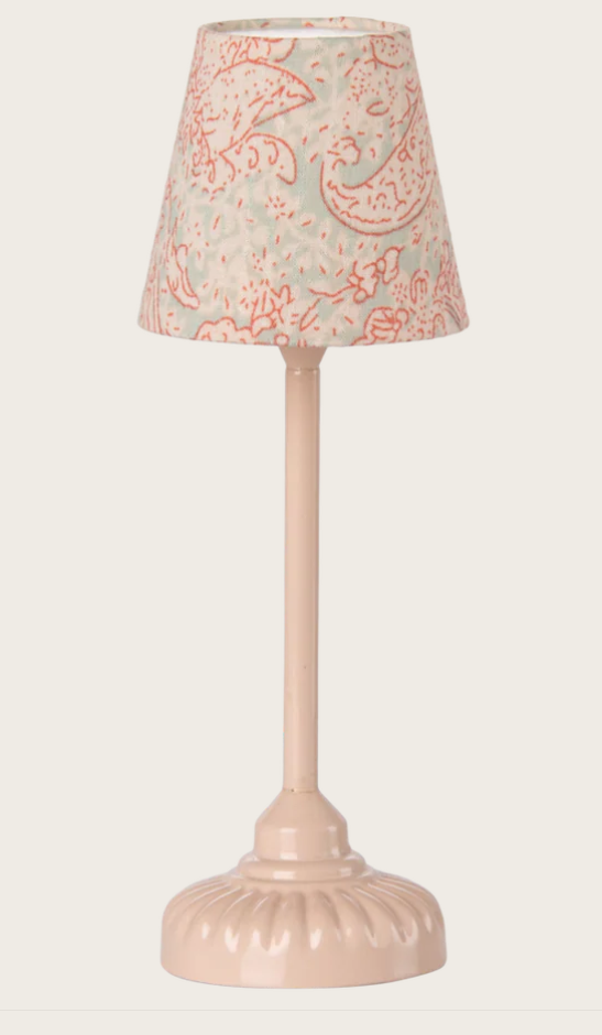 Small pink lamp with a patterned shade on a white background