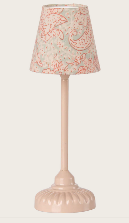 Small pink lamp with a patterned shade on a white background