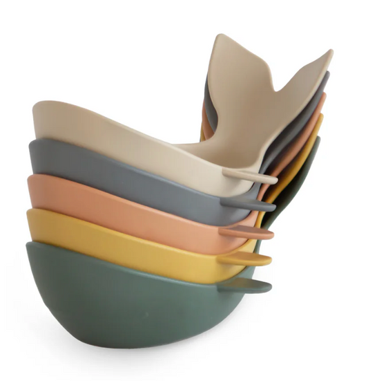 Stack of colorful toys with whale-shaped ends on a white background
