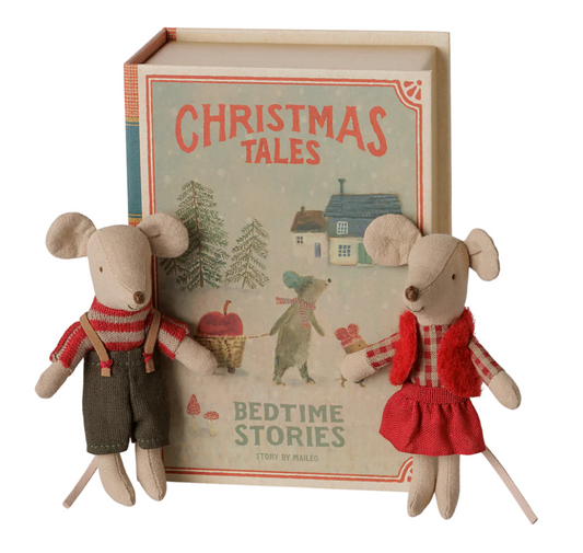 Maileg Christmas twin mice wearing red gingham and striped outfits standing in front of "Christmas Tales Bedtime Stories" book on white background