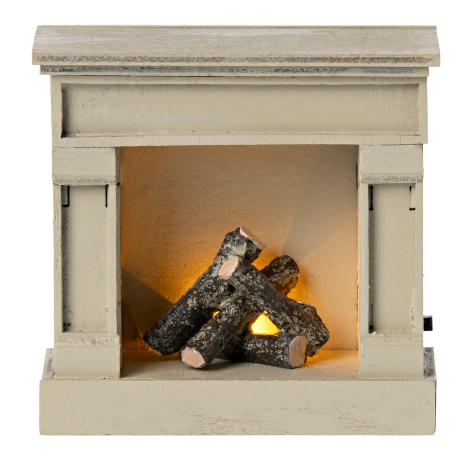 Toy wooden fireplace with logs on a white background with lighted logs