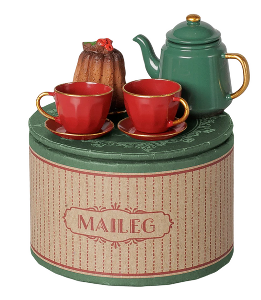 Miniature tea set with red cups and saucers, a bundt cake, and a green teapot, on top of a round box with Maileg branding