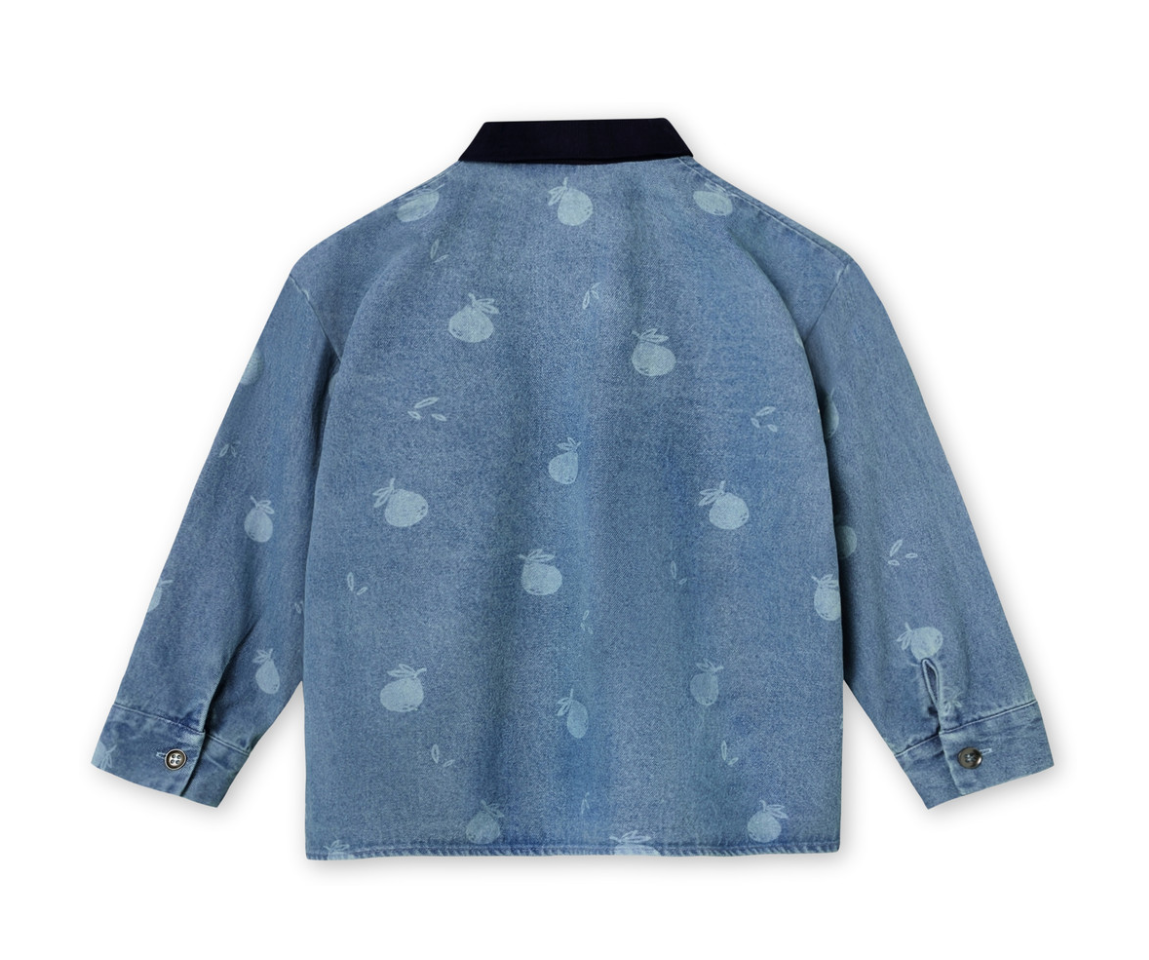 Back view of denim shirt for children with buttons down the front, long sleeves, and a navy corduroy collar, printed with a pale blue apple design