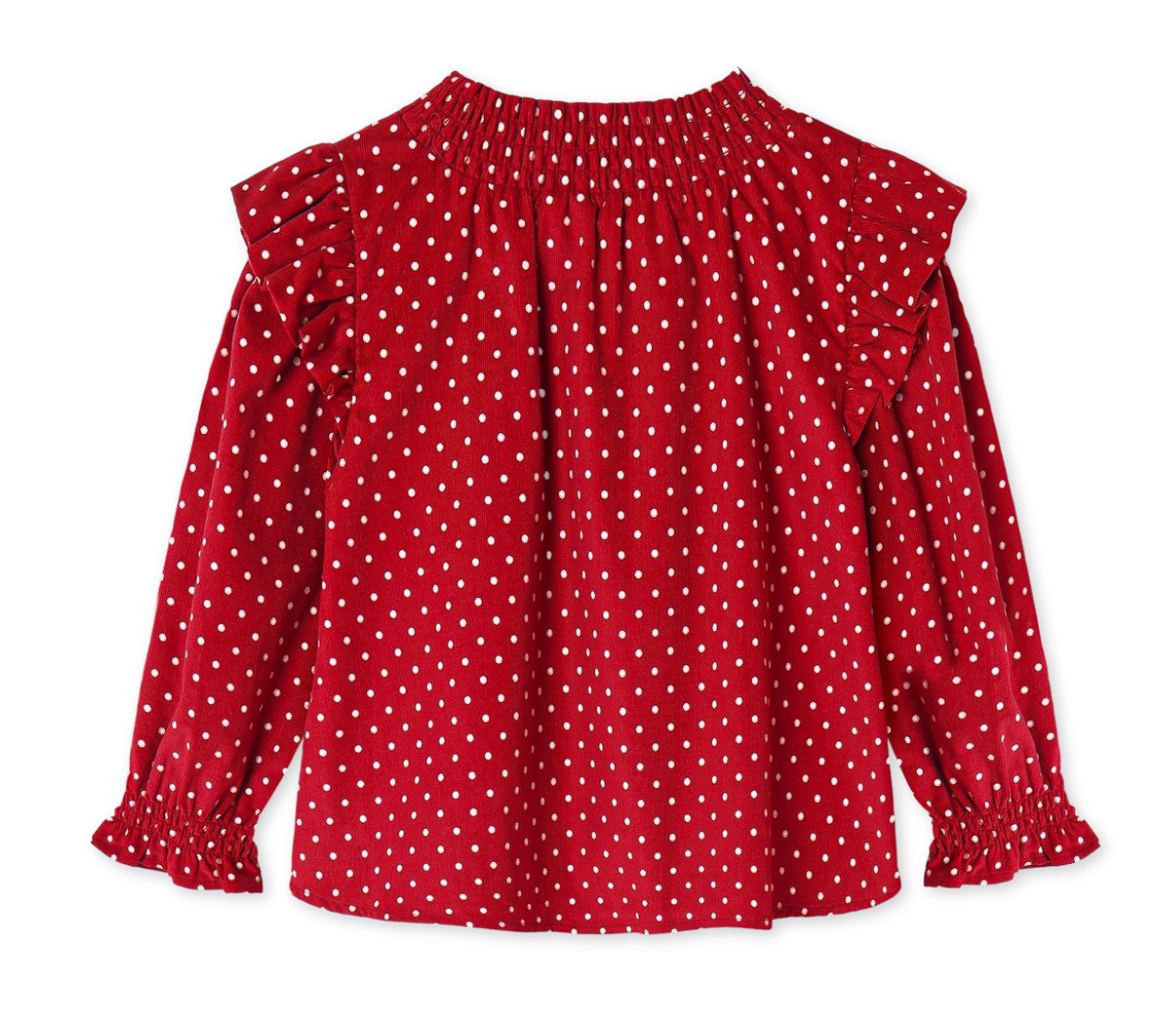 Back of red ruffly long sleeve blouse with white polka dots on a white background