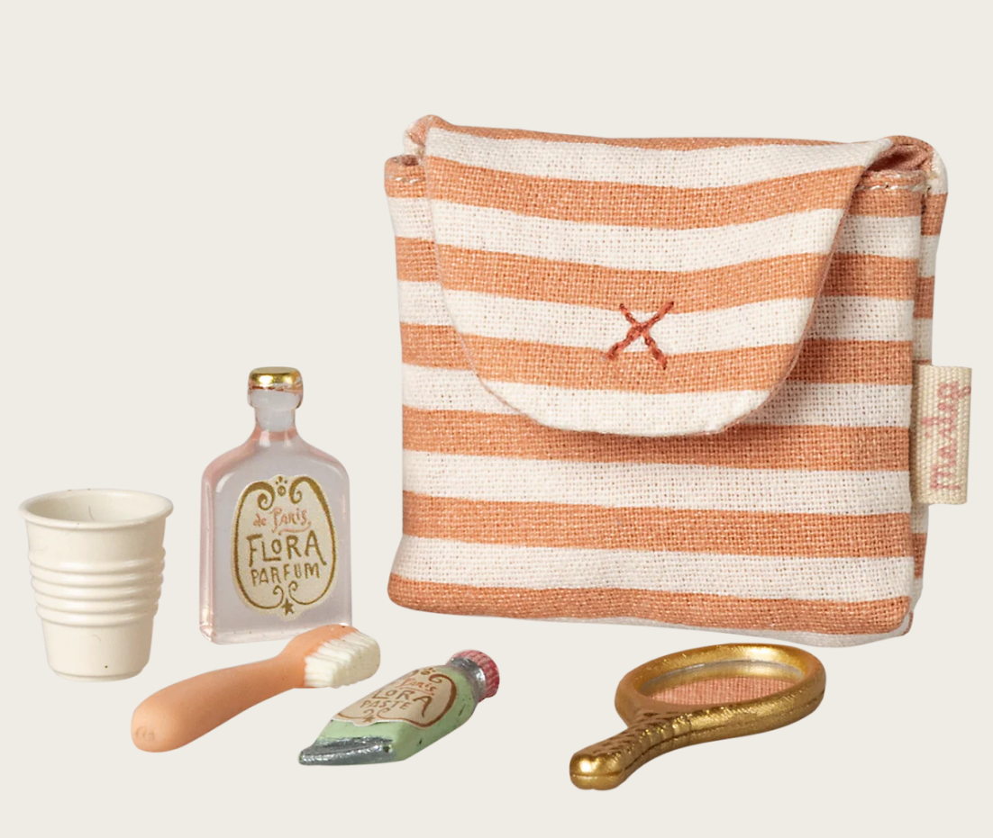 Striped pouch with small mouse doll toiletry items including a bottle, cup, and brush on a beige background