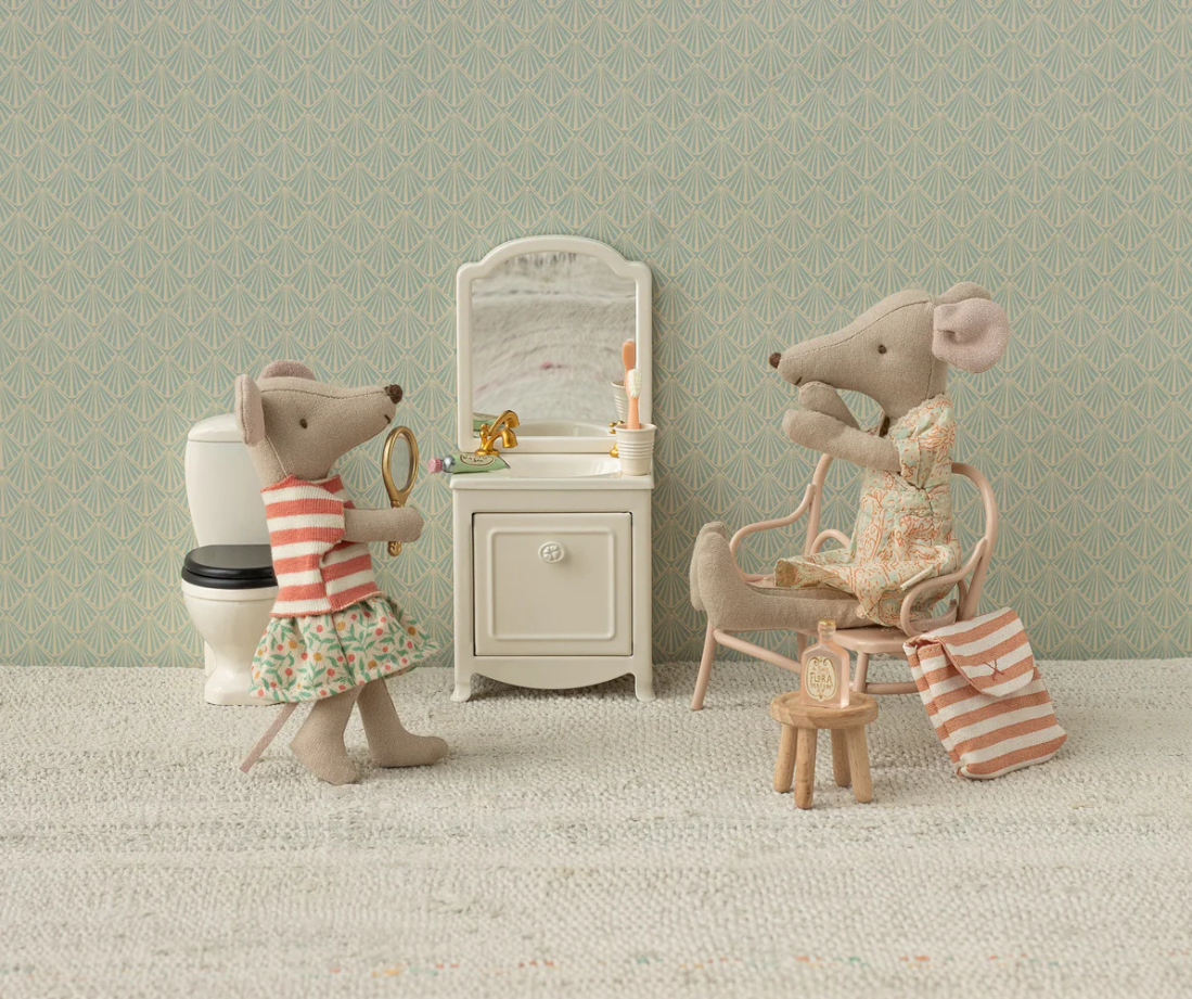 Two toy mice in a bathroom setting with a sink, mirror, and toilet.