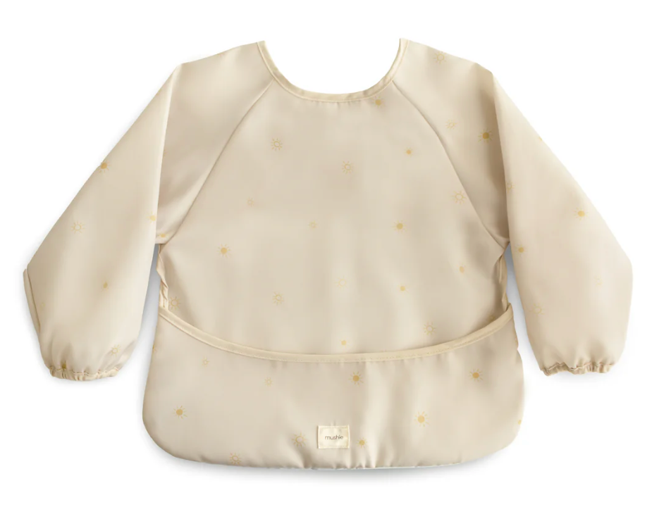 Beige long-sleeve bib decorated with small suns, with a small logo on a white background