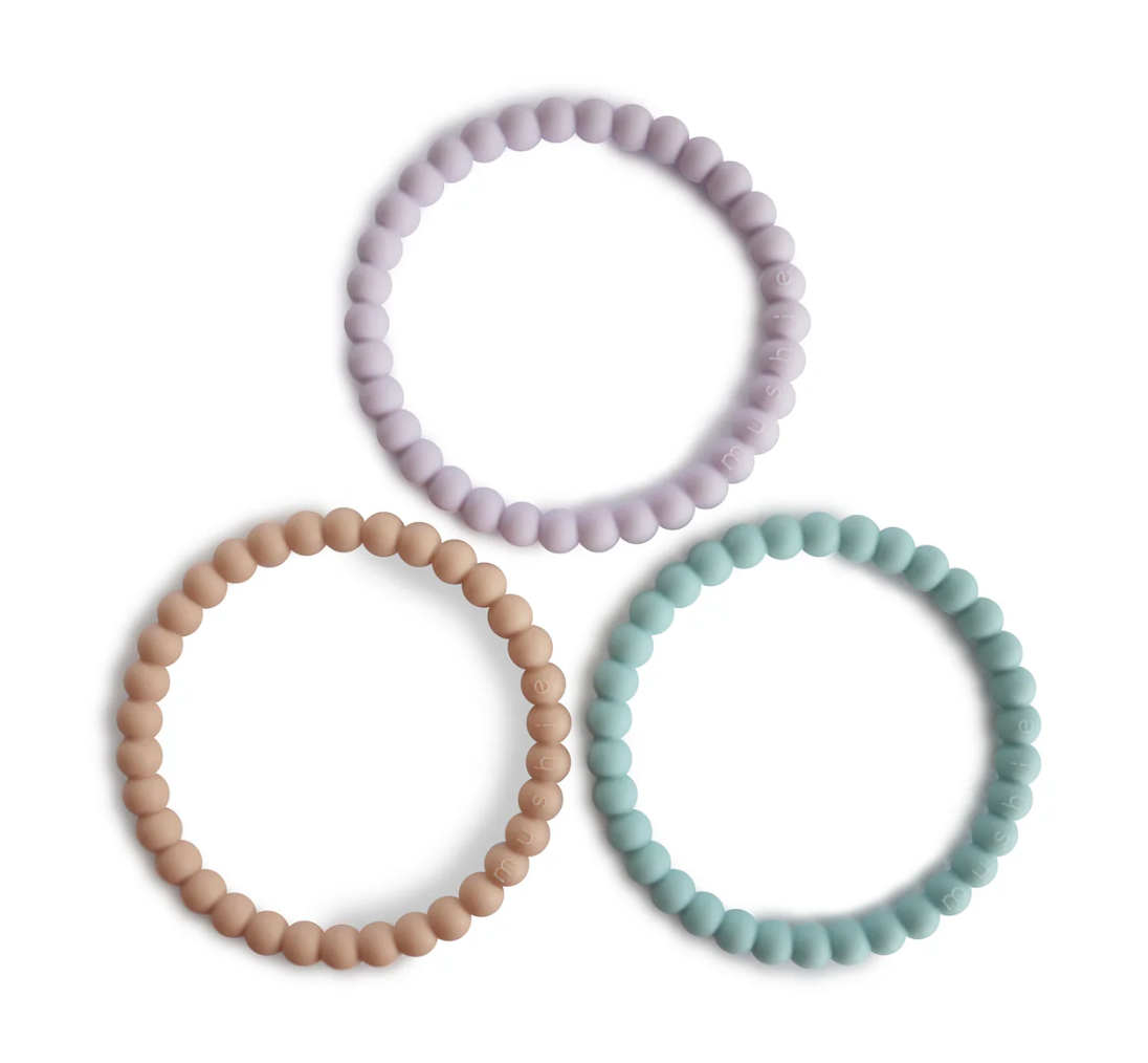 Three beaded teething bracelets in pastel colors on a white background