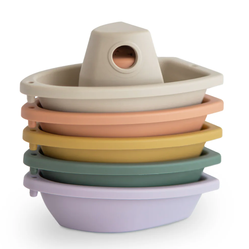 Stack of colorful bath toy boats on a white background