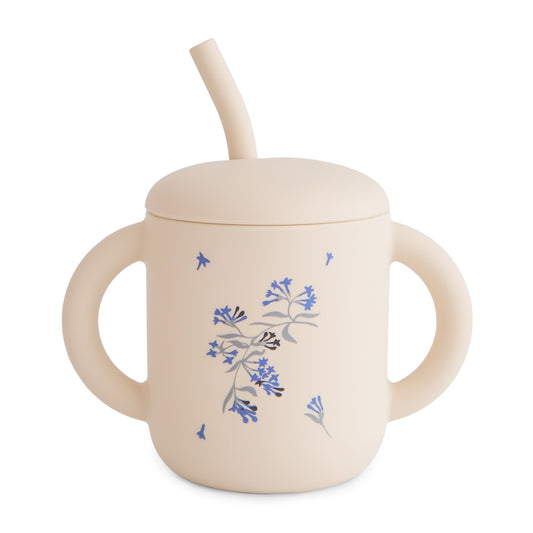 Beige sippy cup with floral design and straw on a white background