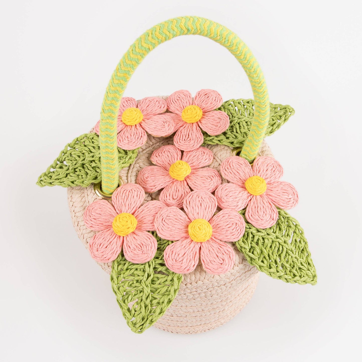 Crocheted basket with pink flowers and green leaves on a white background