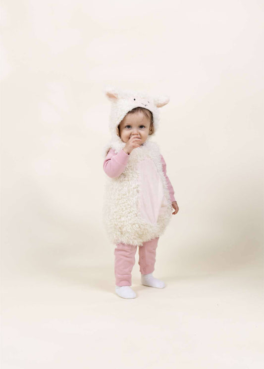 A toddler wearing a fluffy white sheep costume with a pink belly panel, pink long-sleeve top, and matching pink pants, standing against a plain cream studio background.