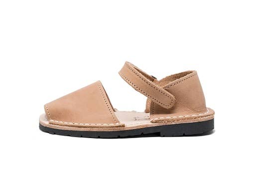 Beige sandal with a black sole on a white background