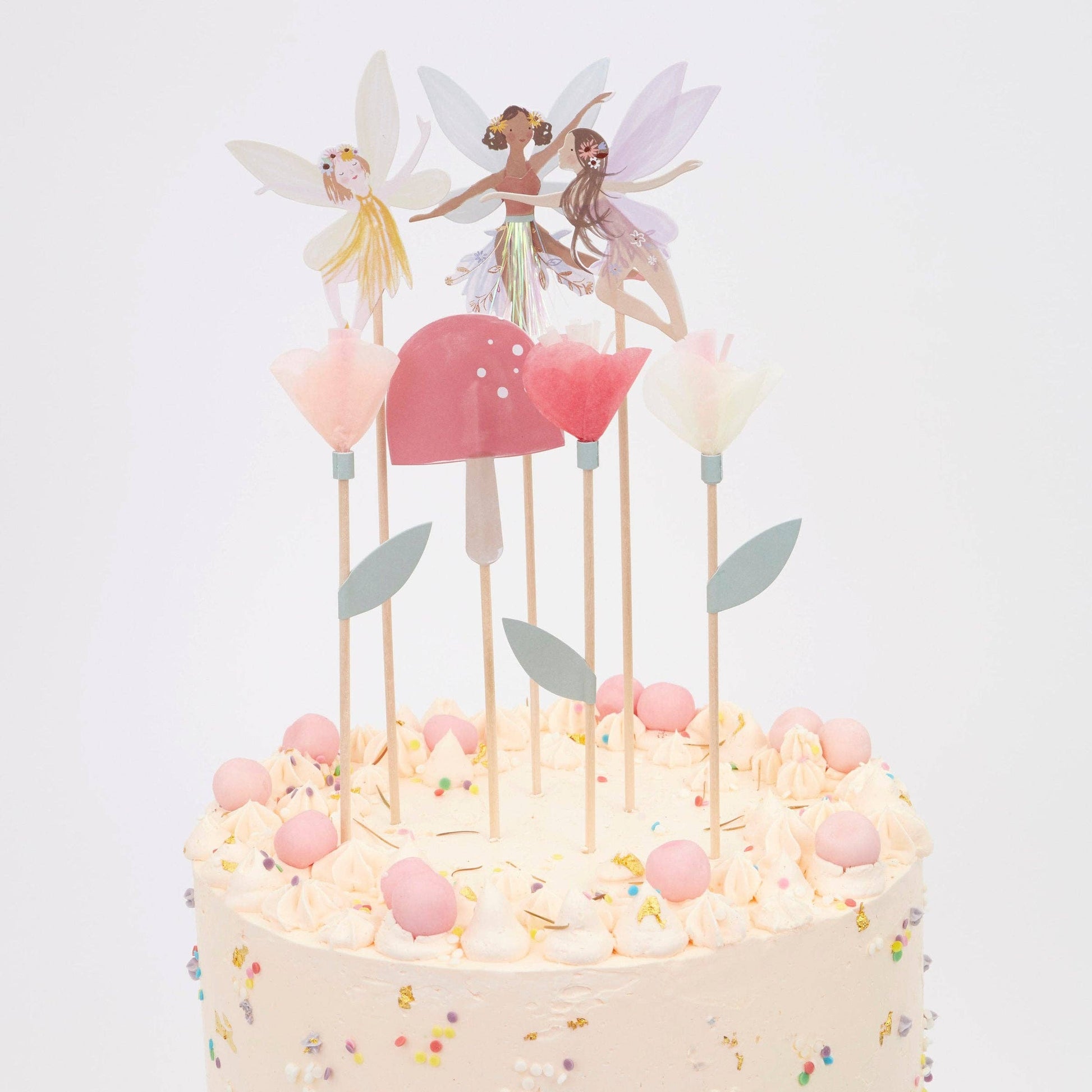 Decorative cake topper with fairy figurines on a white background