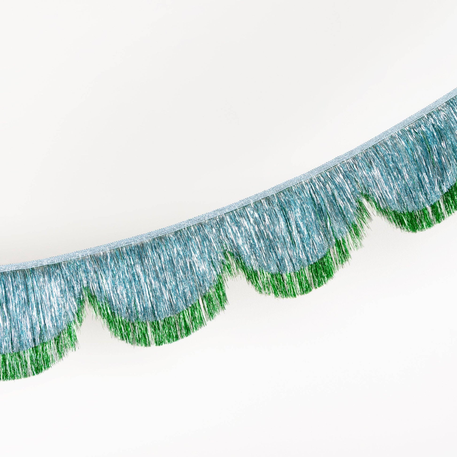 Close-up of metallic green fringe on a white background
