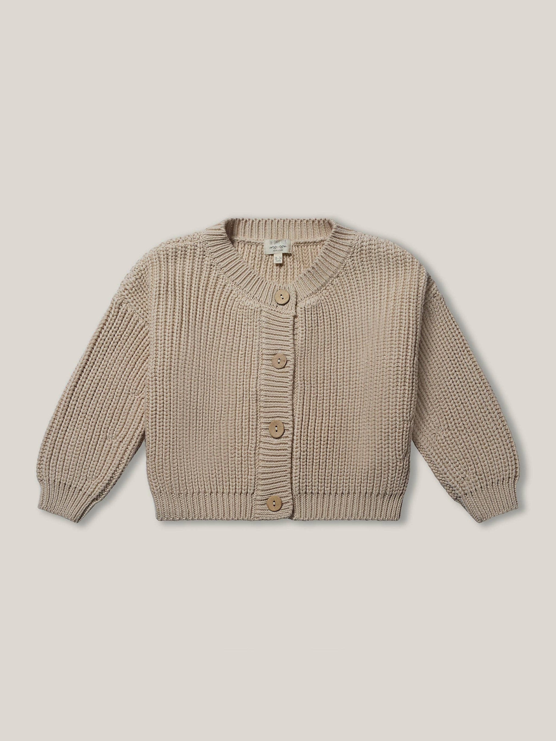 Beige knitted cardigan on a beige background