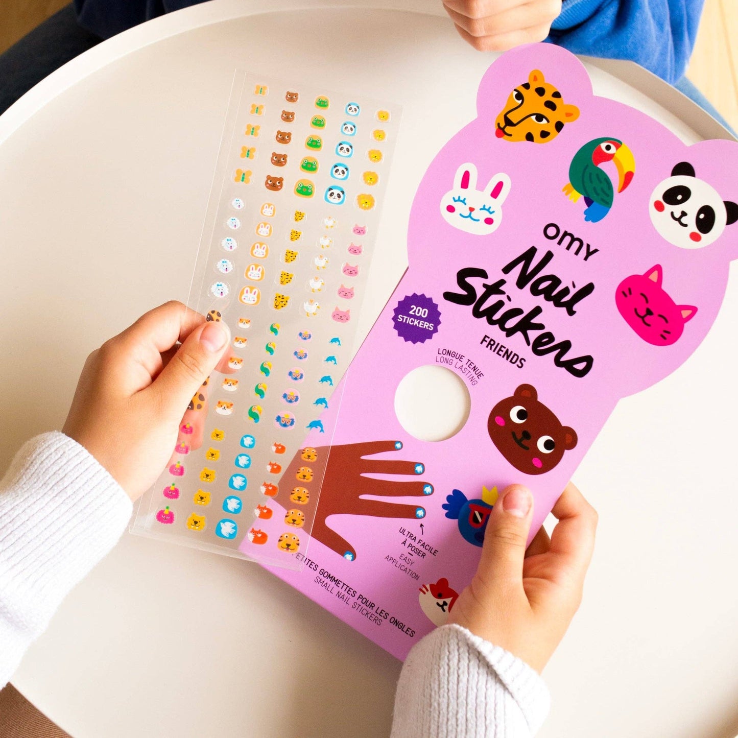 Pink packaging of nail stickers with colorful designs on a white surface
