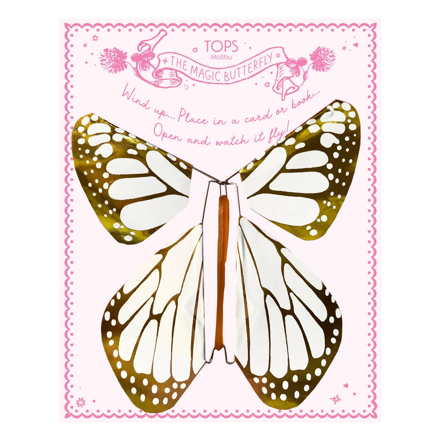 Butterfly-shaped toy with gold and white wings on a pink background