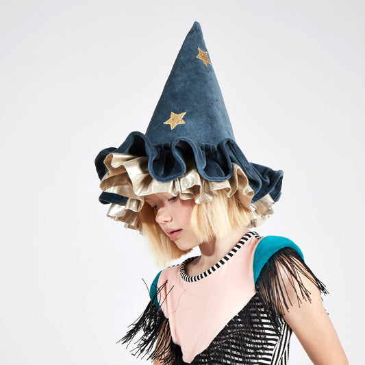Person wearing a blue witch hat with gold stars on a white background