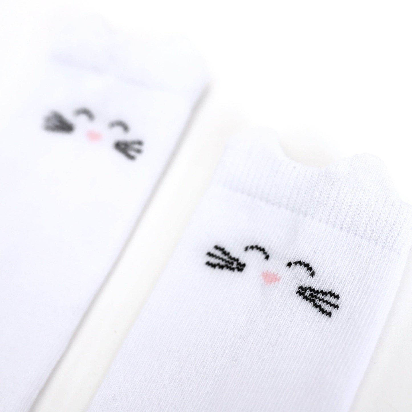 White socks with black cat face designs on a white background