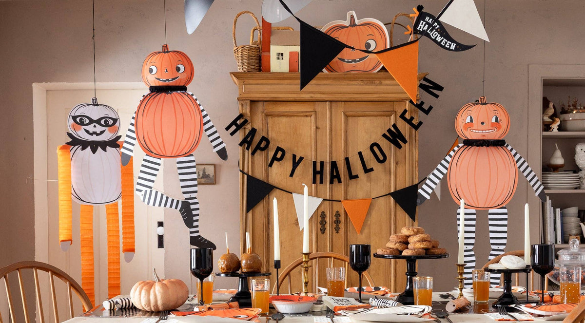 A dining room scene with lots of Halloween decor from My Mind's Eye, including three paper jackolanterns.